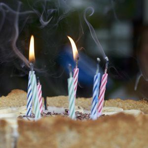 Photo of some candles on a birthday cake illustrating somebody's birthday that our email reminder app and SMS reminder app can send you reminders about
